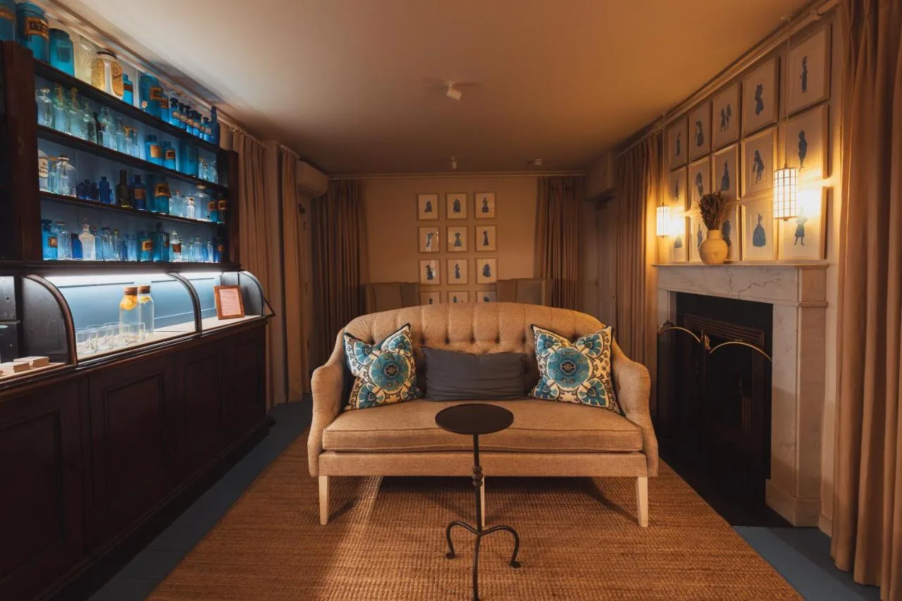 a living room with a chair and a table at No 15 by GuestHouse, Bath in Bath
